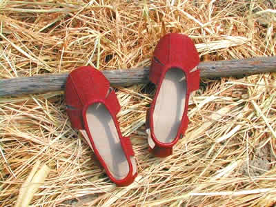 Mother stitches him a pair of red temple shoes.